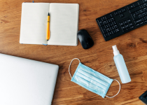 Mask and sanitizer on the desktop, near keyboard